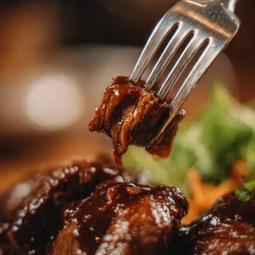 Detalle de la ternera melosa cocinada a baja temperatura deshaciéndose.