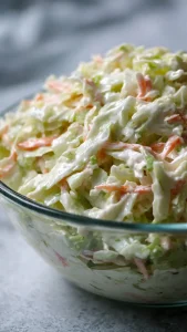 Bol de ensalada de col coleslaw cremosa y crujiente lista para servir.